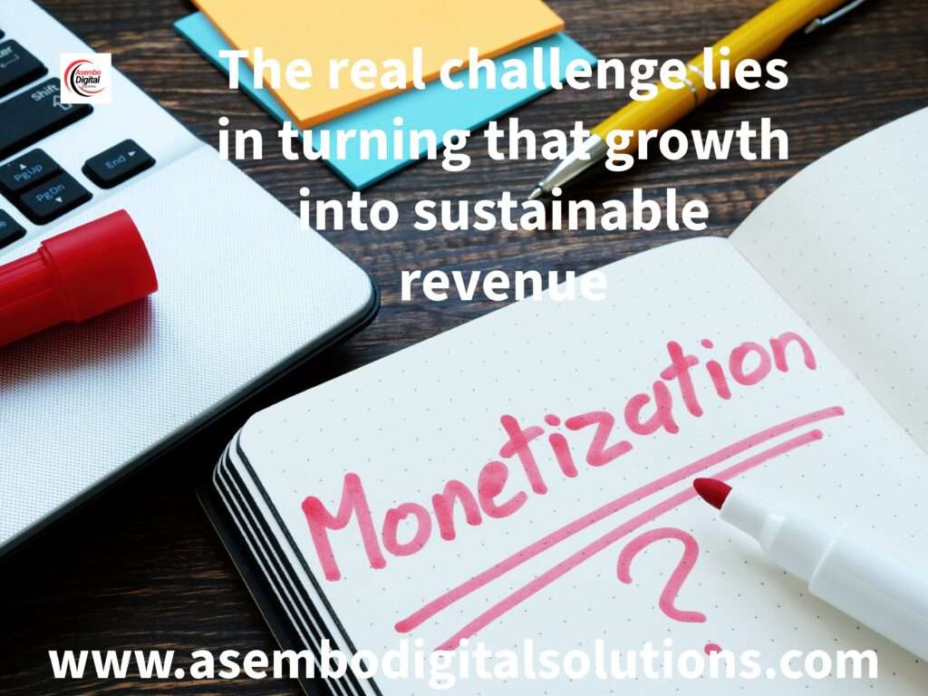 Open notebook with the word 'Monetization?' written in red, placed next to a red marker and a laptop. The text overlay reads: 'The real challenge lies in turning that growth into sustainable revenue.' At the bottom, the website www.asembodigitalsolutions.com and the Asembo Digital Solutions logo are included.